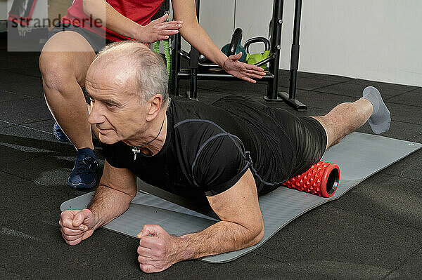 junges Mädchen und alter Mann trainieren im Fitnessstudio