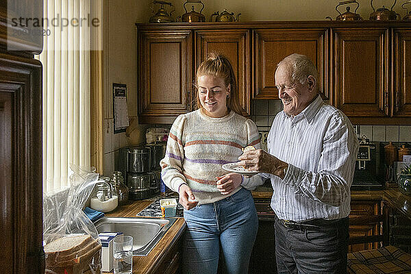 Älterer Mann mit betreuter Wohnfrau  die das Frühstück organisiert