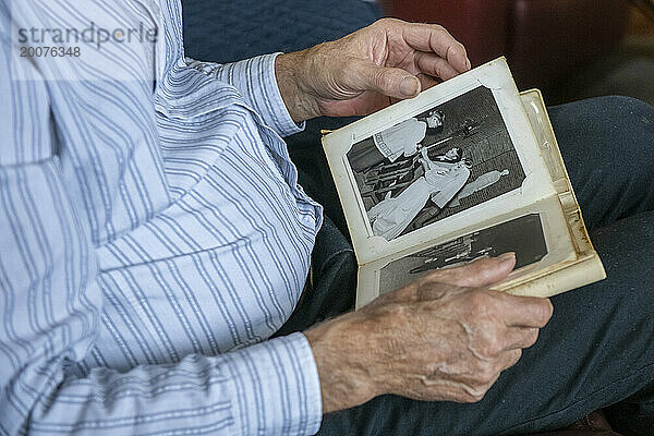 Close up of Elderly man looking at old photos of his wife