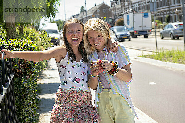 Junge Mädchen auf der Straße spielen und scherzen beim Gehen in der Öffentlichkeit