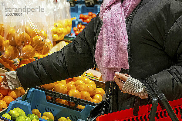 Afroamerikanische Frau erntet Orangen in einem Supermarkt