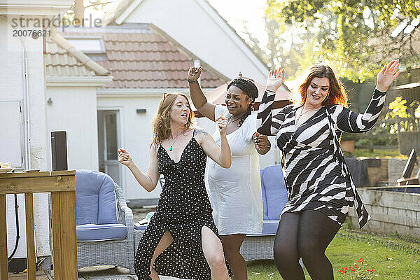 Frauen tanzen und haben Spaß draußen bei einer Sommergartenparty