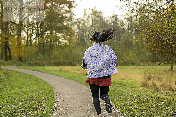 Gesunde  fitte Frau läuft durch den Park und hält sich fit