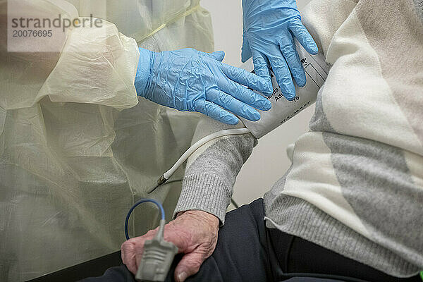 Ältere Dame in einem Krankenhausbett unter Beobachtung mit gesundheitlichen Problemen. Herzmonitor und Blutentnahme für Tests durch einen Arzt