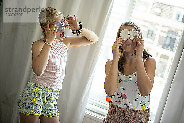 Junge Mädchen  Schwestern  die sich schminken  um zu spielen und Spaß zu haben  sich zu verstecken und zu suchen