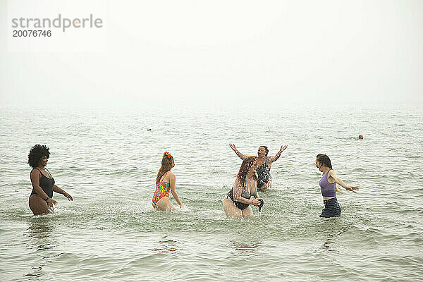 Eine gemischte Gruppe Freundinnen  die Spaß am Strand haben.