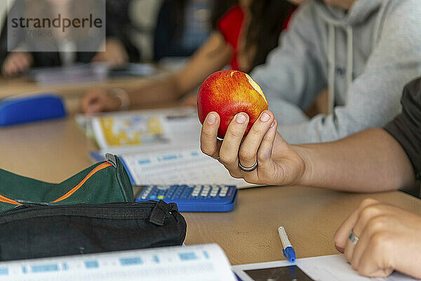 Student isst einen gesunden Apfel