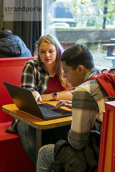 Schüler und Lehrer arbeiten an einem Laptop