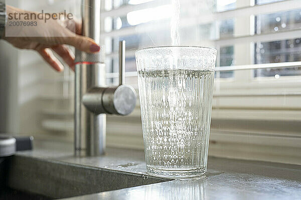 Dame füllt ihr Glas mit frischem  sauberem Wasser