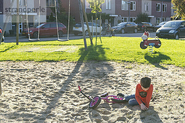 Kleiner Junge spielt in Frieden in einer Sandgrube in einem örtlichen öffentlichen Park
