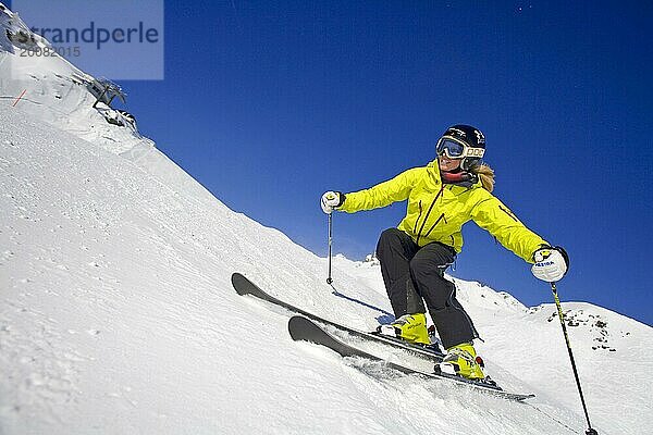 Skifahrerin in Action  blonde Frau  25  30  Jahre  Abfahrt am Hang  Österreich  Europa