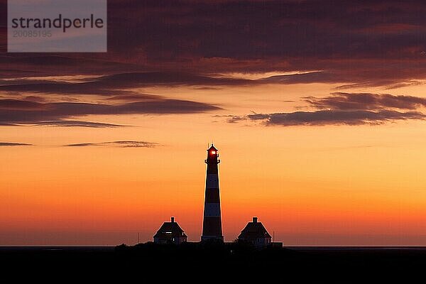 Leuchtturm Westerheversand als Silhouette vor orangefarbenem Abendhimmel  Westerhever  Nationalpark Wattenmeer  Nordfriesland  Schleswig Holstein  Deutschland  Europa