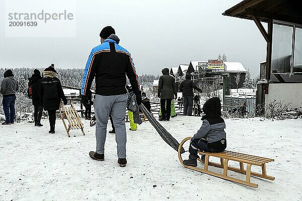 Der erste Schnee ist da. Trotz Corona Pandemie freuen sich Familien mit Kindern über winterliche Verhältnisse auf der Rodelbahn in Torfhaus im Harz  27.12.2020