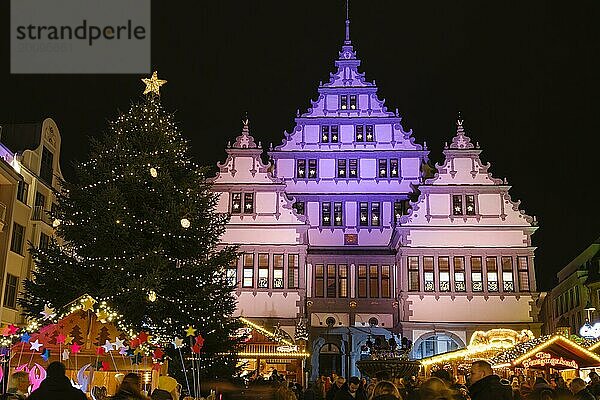 Weihnachtsmarkt vor farbig beleuchtetem Rathaus  Nachtaufnahme  Paderborn  Westfalen  Nordrhein-Westfalen  Deutschland  Europa