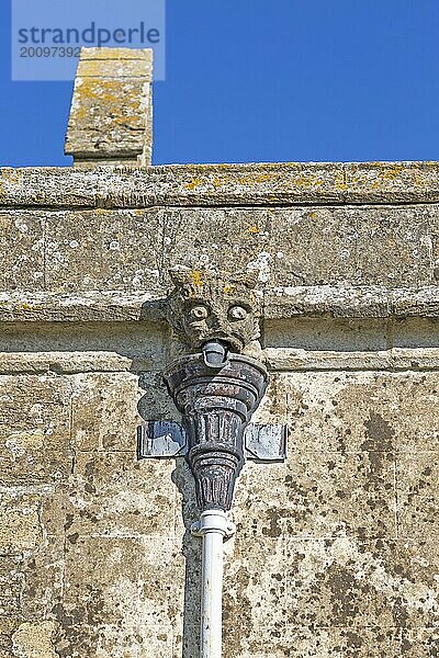 Wasserspeier mit groteskem Gesicht Abflussrohr an Wand mittelalterliche Kirche Saint John  Inglesham  Wiltshire  England  UK