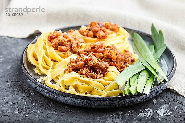 Tagliatelle Bolognese Nudeln mit Hackfleisch auf schwarzem Betonhintergrund. Seitenansicht  Nahaufnahme