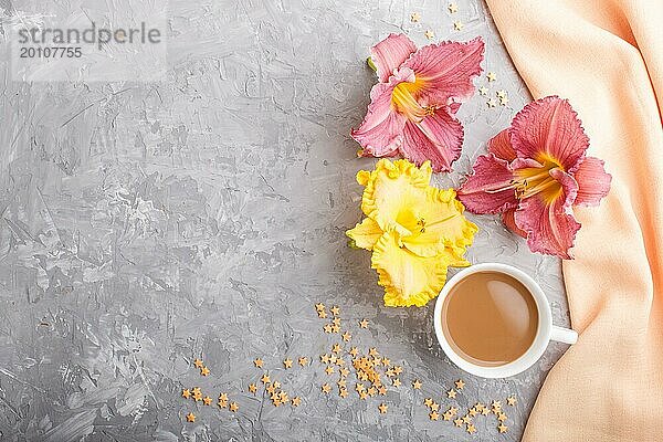 Gelbe und lila Taglilien Tasse Kaffee auf einem grauen Hintergrund Beton  mit orangefarbenen Textil. Morninig  Frühling  Mode Zusammensetzung. Flachlage  Draufsicht  Kopierraum
