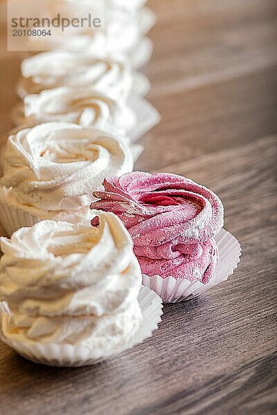 Rosa und weiße hausgemachte Marshmallows auf einem grauen hölzernen Hintergrund. selektiver Fokus