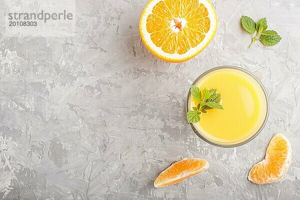 Glas Orangensaft auf einem grauen Hintergrund aus Beton. Morninig  Frühling  gesundes Getränk Konzept. Draufsicht  Kopie Raum  flach legen