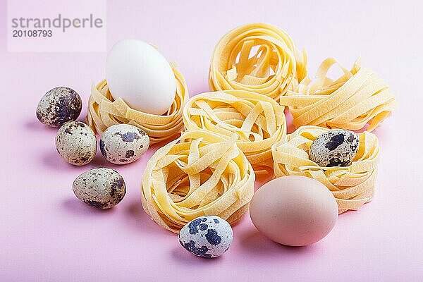 Rohe ungekochte Tagliatelle Nudeln mit Wachteleiern auf rosafarbenem Hintergrund. Seitenansicht  Nahaufnahme