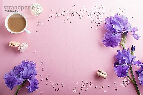Lila Irisblüten und eine Tasse Kaffee auf einem rosa pastellfarbenen Hintergrund. Morninig  Frühling  Mode Zusammensetzung. Flachlage  Draufsicht  Kopierraum