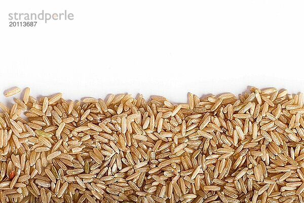 Textur von braunem Reis vor weißem Hintergrund. Ansicht von oben. Raum kopieren