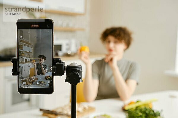 Professionelle Ernährungsberaterin filmt mit ihrem Smartphone ein Tutorial über gesunde Ernährung in ihrer Küche