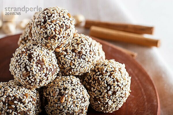 Energiekugelkuchen mit Mandeln  Sesam  Cashew  Walnüssen  Datteln und gekeimtem Weizen auf Holzbrett  Seitenansicht  Nahaufnahme