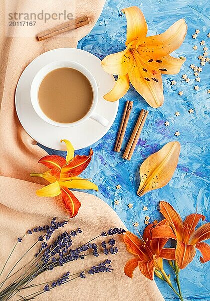 Orange Taglilie und Lavendelblüten und eine Tasse Kaffee auf einem blauen Betonhintergrund  mit orangefarbenem Textil. Morninig  Frühling  Mode Zusammensetzung. Flachlage  Draufsicht  Nahaufnahme