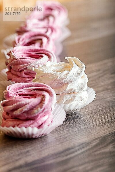 Rosa und weiße hausgemachte Marshmallows auf einem grauen hölzernen Hintergrund. selektiver Fokus