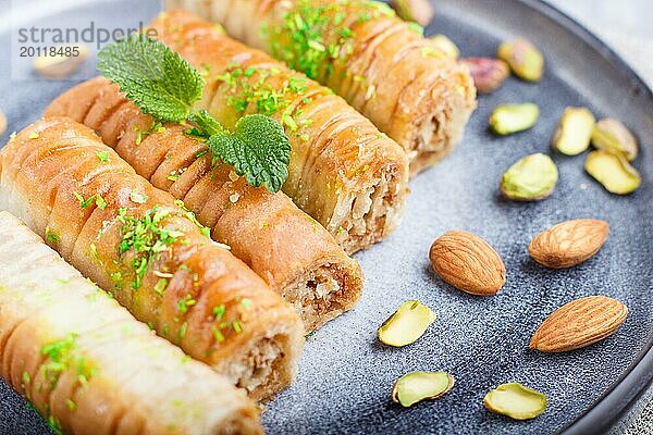 Baklava  traditionelle arabische Süßigkeiten in einem grauen Keramikteller auf einem grauen Betonhintergrund. Seitenansicht  Nahaufnahme  selektiver Fokus