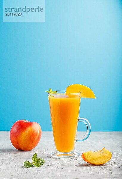 Glas Pfirsichsaft auf einem grauen und blauen Hintergrund. Morninig  Frühling  gesundes Getränk Konzept. Seitenansicht  Kopie Raum