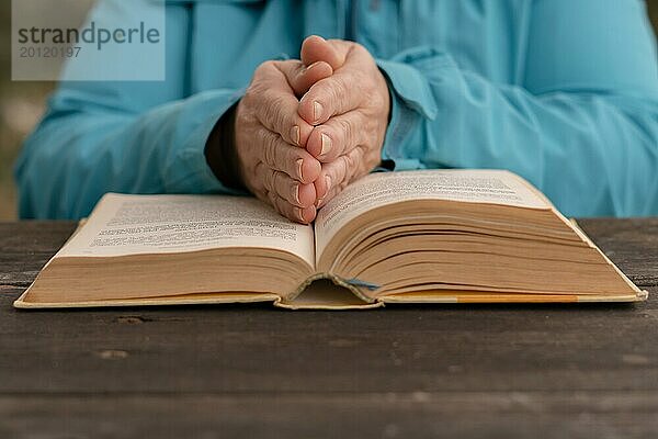 Frau mit ihren Händen auf einem heiligen Buch in Gebetshaltung