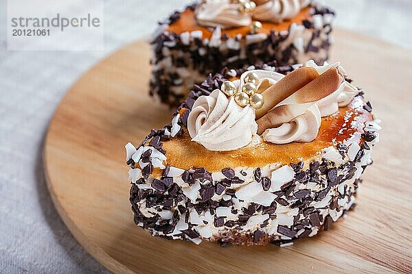 Kuchen mit Schokoladenstückchen und Sahne Dekorationen auf Holzbrett auf weißem Hintergrund. selektiven Fokus  Nahaufnahme