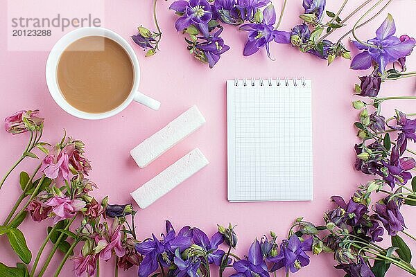Rosa und lila Akelei Blumen und eine Tasse Kaffee mit Notizbuch auf pastellrosa Hintergrund. Morninig  Frühling  Mode Zusammensetzung. Flachlage  Draufsicht  Kopierraum