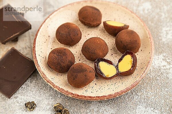 Japanischer Reis süße Brötchen Schokolade Mochi gefüllt mit Sahne und Tasse grüner Tee auf braunem Beton Hintergrund. Seitenansicht  Nahaufnahme  selektiver Fokus