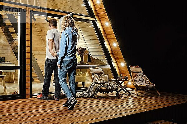 Ein Paar kehrt nach einem Spaziergang im Freien spät in der Nacht in ein kleines Blockhaus zurück