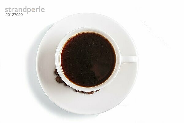 Eine Tasse Kaffee mit Kaffeebohnen auf einem Teller  vor weißem Hintergrund  Draufsicht  Nahaufnahme