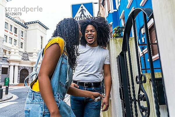 Niedriger Blickwinkel Porträt eines glücklichen afrikanischen Freunde lachen in den Eingang eines Hauses