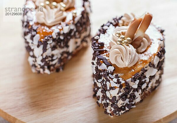 Kuchen mit Schokoladenstückchen und Sahne Dekorationen auf Holzbrett auf weißem Hintergrund. selektiven Fokus  Nahaufnahme