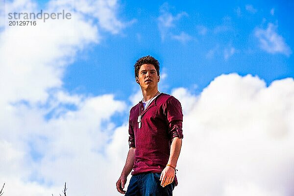 Porträt eines männlichen Teenagers im Freien vor blauem Himmel