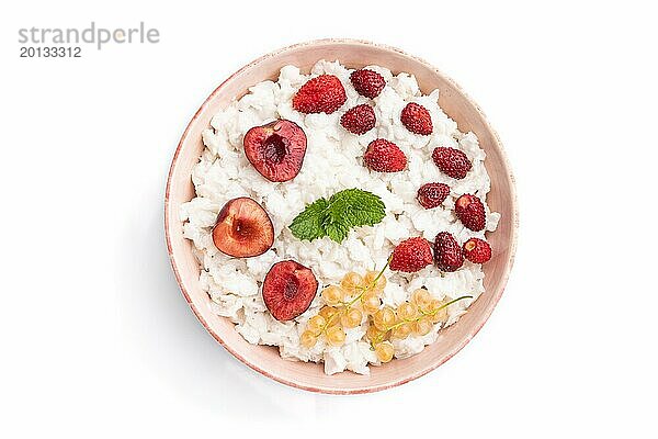 Reisflockenbrei mit Milch und Erdbeere in Keramikschale vor weißem Hintergrund. Draufsicht  Flachlage  Nahaufnahme
