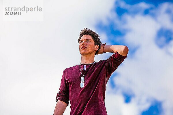 Porträt eines männlichen Teenagers im Freien vor blauem Himmel