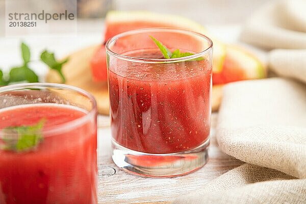 Wassermelonensaft mit Chiasamen und Minze in einem Glas auf einem weißen Holzhintergrund mit Leinenstoff. Gesundes Getränk Konzept. Seitenansicht  Nahaufnahme  selektiver Fokus