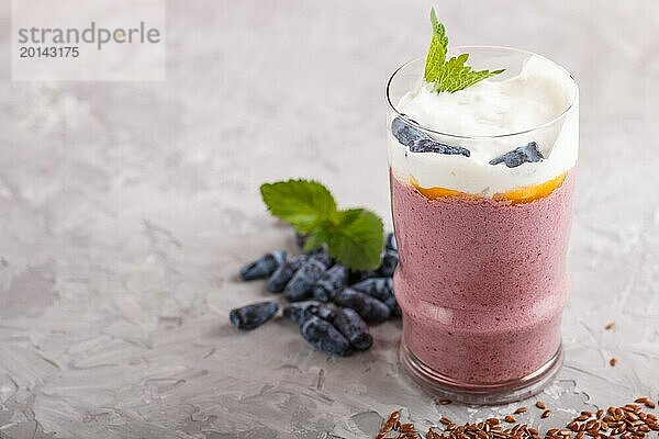 Smoothie mit Geißblatt  Leinen und Chia in einem Glas auf grauem Betonhintergrund. Seitenansicht  Nahaufnahme  selektiver Fokus