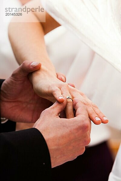 Bräutigam steckt Ehering auf den Finger der Braut