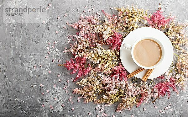 Rosa und rote Astilbe Blumen und eine Tasse Kaffee auf einem grauen Beton Hintergrund. Morninig  Frühling  Mode Zusammensetzung. Flachlage  Draufsicht  Kopierraum