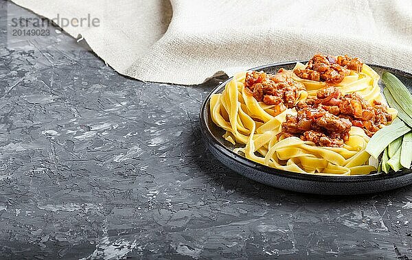 Tagliatelle Bolognese Nudeln mit Hackfleisch auf schwarzem Betonhintergrund. Seitenansicht  Nahaufnahme  Kopierbereich