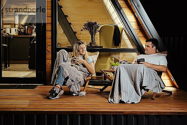 Ein freundliches Paar sitzt abends auf der Terrasse und unterhält sich