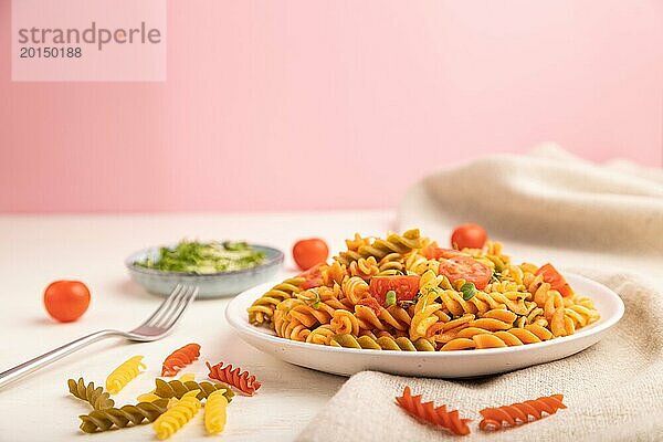 Tortiglioni Grießnudeln mit Tomaten und Mikrogrünsprossen auf weißem und rosa Hintergrund und Leinenstoff. Seitenansicht  Kopierraum  selektiver Fokus